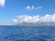 ダイヤモンドヘッドを背景に潮を吹くくじら