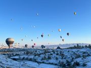 近くを多くの気球が飛んでいて、ギョレメの岩と雪、青空に浮かぶ気球の景色は圧巻でした