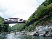 川から見える橋と電車と緑の山々